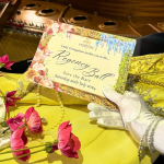 gloved hand holding an invitation